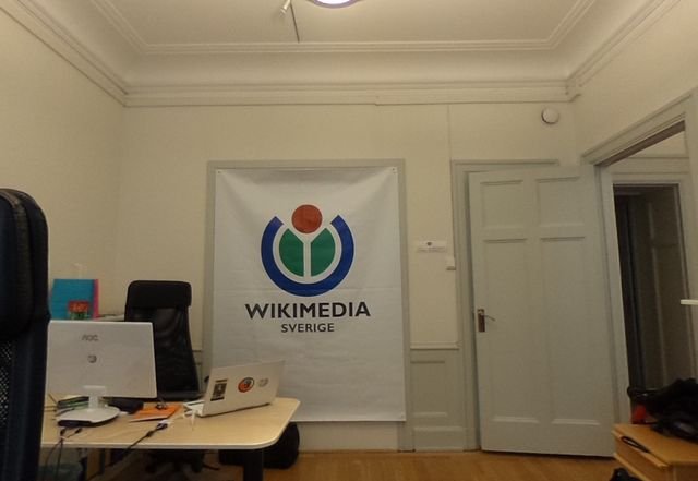 An office desk with a monitor and a printed display banner behind it