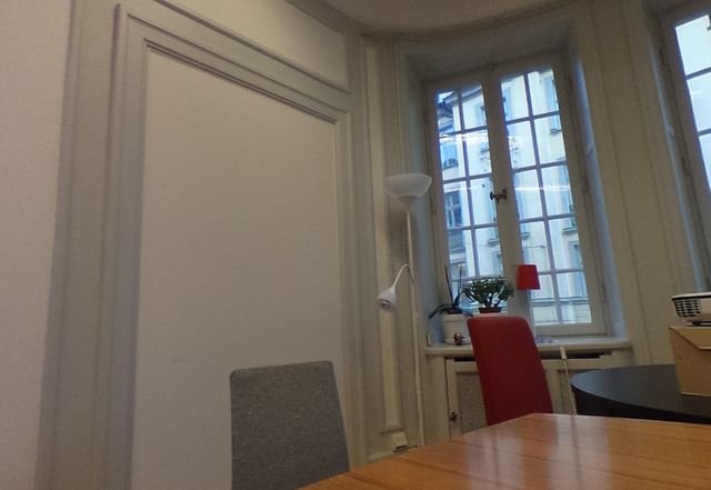 A meeting room with a long table, chairs and a whiteboard