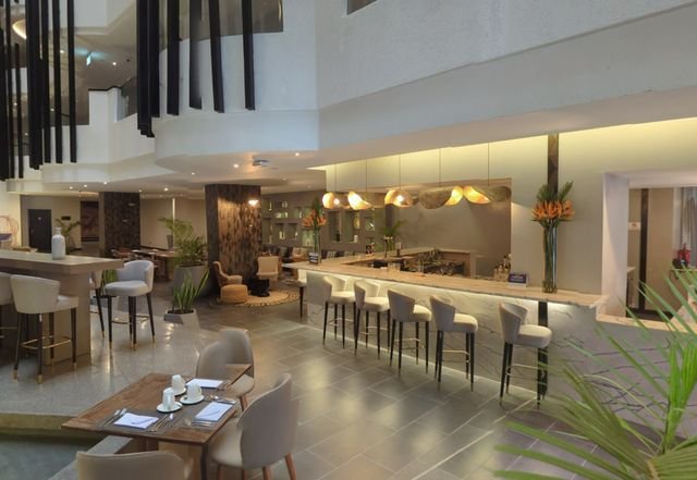A hotel bar and reception seating area seen from the entrance