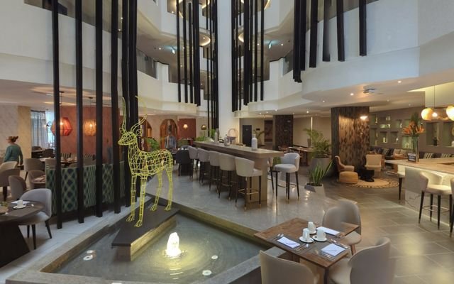 A hotel lobby with a water feature and bar seating